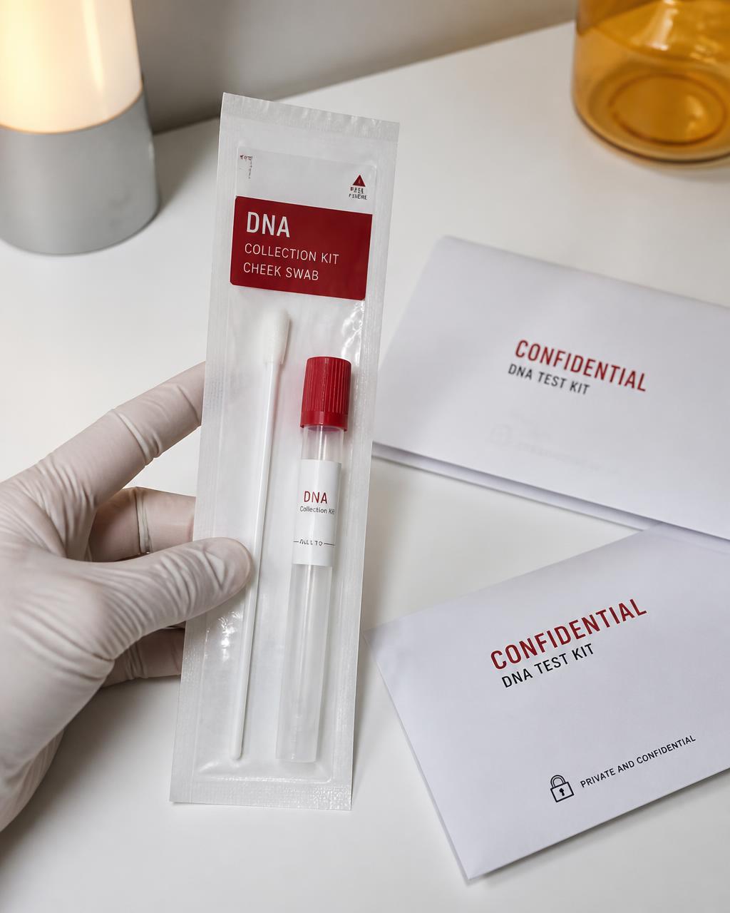 Sterile cheek swab DNA collection kit next to sealed confidential envelopes